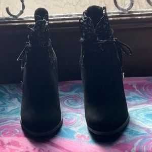 Black heeled side zipper boots with lace and tie accents by Venus